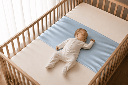 Baby asleep on their back on a sky blue silk cot sleeve in a wooden cot – LS Silk AU
